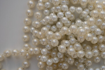 long pearl beads lie on a white table