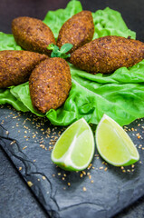 Delicious Lebanese  food, kibbeh (kibe) on black slate stone and granite background.