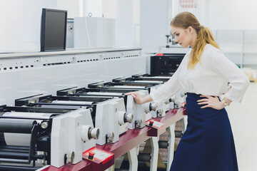 Young woman working in printing factory. Printing Press.