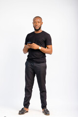 young black handsome man standing texting with his smartphone with a smile on his face