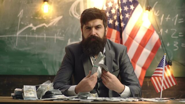 Serious bearded man holding dollar bills. Portrait of a satisfied businessman holding lots of cash. Man with a bundle of money. Success economy. American boss.