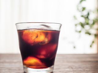 明るい窓辺に置かれたアイスコーヒー