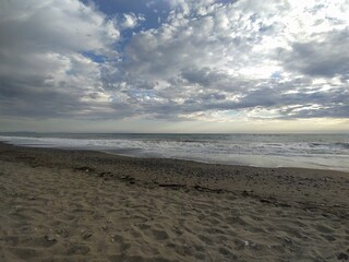 Sea in Marina di Bibbona at sunset, evening sky with clouds, Italy.  Mediterranean Sea, beautiful sandy beach, waves.