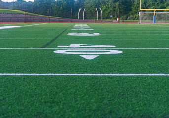 Obraz premium Orange High School Track and Green Artificial Football Field Early Morning