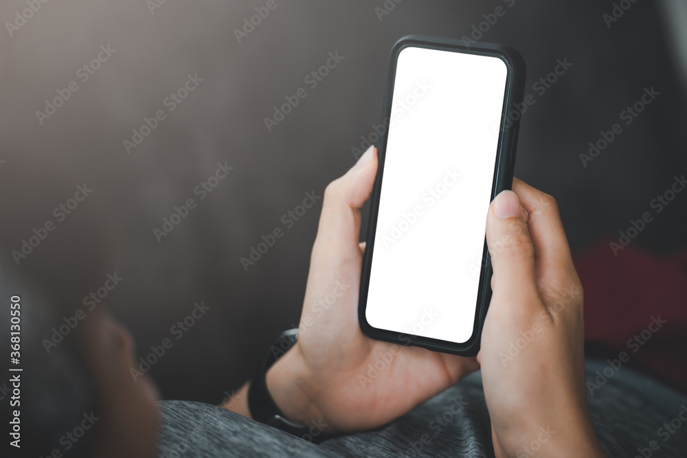 Poster woman's hand holding black mobile phone with blank desktop screen. empty screen for mockup image or 