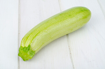 Green young fresh zucchini on wooden table for cooking
