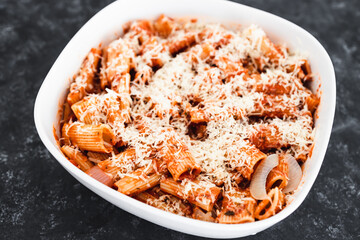 plant-based food, vegan rigatoni pasta bake with red pesto sauce and dairy free cheese before going in the oven
