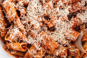 plant-based food, vegan rigatoni pasta bake with red pesto sauce and dairy free cheese before going in the oven