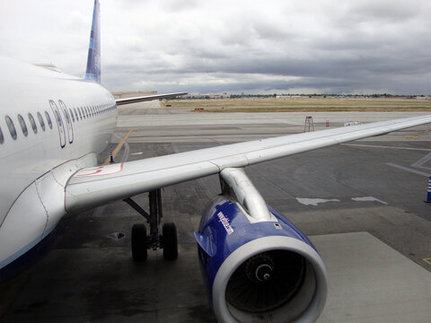 Side of JetBlue Plane featuring wing and Jet Engine