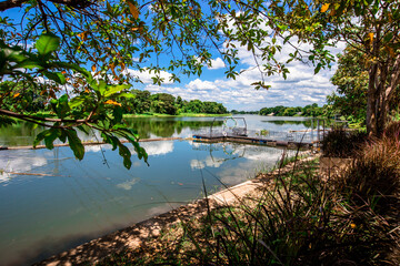 The natural background of the jetty by the river, with clear skies and high-voltage electrical cables crossing, clear air during the day.