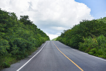 Road to mountain - A long straight road leading towards a nature green tree on the mountains , Asphalt road in Thailand