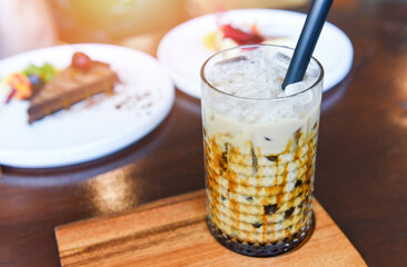 Bubble milk tea in glass on the wooden table with cake - Taiwan milk tea