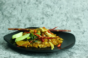 Rice noodles cooked with spicy seasoning with sliced meat, eggs, and vegetables.