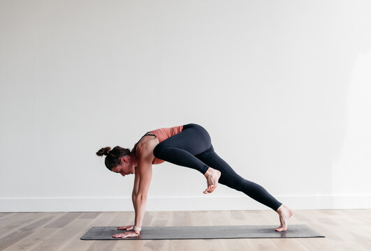 Woman doing yoga flow in white studio