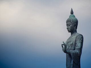 Fototapeta na wymiar Buddha statue standing in phutthamonthon Bangkok Thailand on rainy sky for background