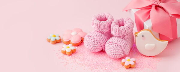 Pair of small pink baby socks, cookies, gift box on pink background with copy space for your warm message, baby shower, first newborn party background, copy space, monochrome, banner - 368139141