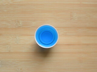 Top view of blue color Mouthwash liquid in round measuring cup