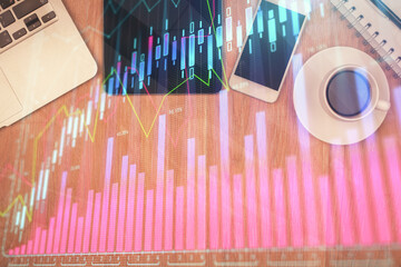 Double exposure of financial chart hologram over desktop with phone. Top view. Mobile trade platform concept.