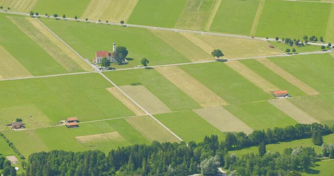 Farming fields, the St. Coloman church and the federal highway B17 near Schwangau, Germany on a hot summer day.