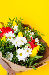 Delicious bouquet of flowers on yellow background. Studio Photo