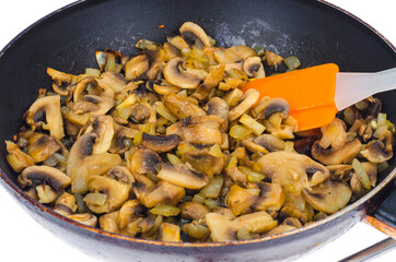 Pan with fried champignons on white plate. Studio Photo