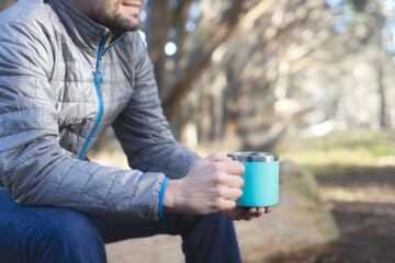 man using reusable cup during hike