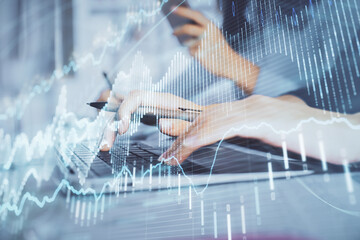 Fototapeta premium Multi exposure of woman hands typing on computer and financial graph hologram drawing. Stock market analysis concept.