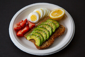 toasted sandwich with avocado,  egg, strawberry and lemon