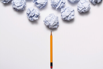 Crumpled paper ball and pencil on the white background
