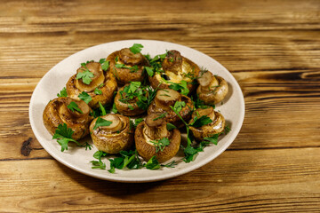 Baked mushrooms in plate on wooden table