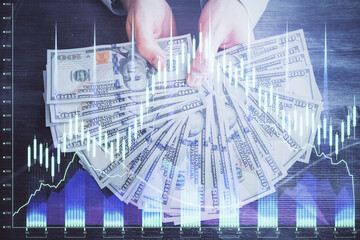 Multi exposure of financial graph drawing hologram and USA dollars bills and man hands. Analysis...