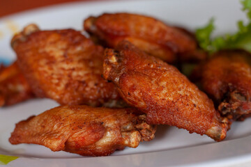 Fried chicken wing in white plate in the kitchen.