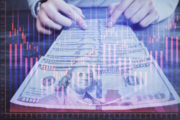 Multi exposure of forex graph drawing hologram and USA dollars bills and man hands. Technical Analysis concept.