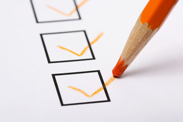 Checklist and pencil close-up on white background

