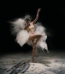 Slim female dancer throwing dust in air