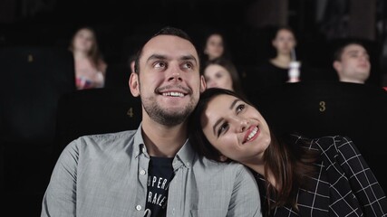 Love couple watching movie in cinema theatre. People enjoying film
