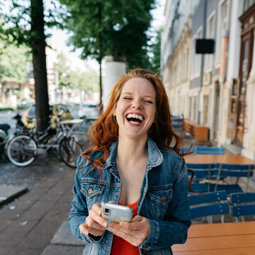 Goofy vivacious young woman laughing at the camera