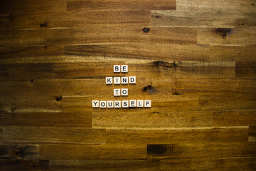 Flat lay photography - Word/s made with lettered tiles on timber background.