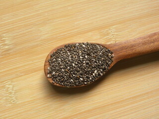 White and black color raw Chia seeds or Salvia hispanica on wooden spoon