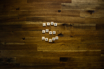Flat lay photography - Word/s made with lettered tiles on timber background.