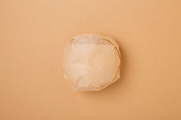 Packed burger, top view. Wrapped hamburger sandwich, blank mock up on craft paper