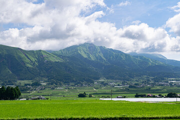 Fototapeta na wymiar 雄大な山脈の脚下に広がる田園風景, 熊本・阿蘇市の絶景