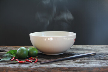 Bowl of hot soup with steaming on wooden table on black background selective focus. hot food concept.