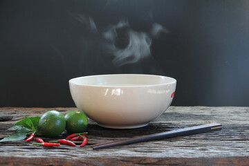 Bowl of hot soup with steaming on wooden table on black background selective focus. hot food concept.