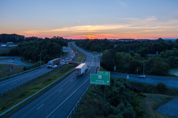 The sun sets over Interstate 270 in Urbana, Frederick County, Maryland. Two tractor trailers pass...