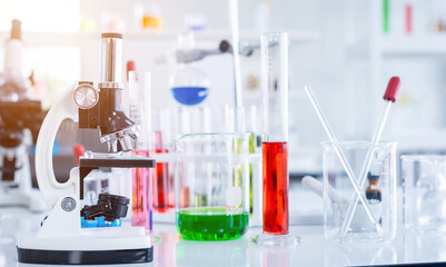 Microscope and test tubes with lab glassware in laboratory background, research and Scientific...