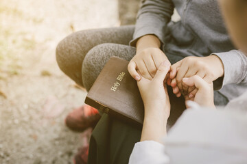 two women pray on the bible.