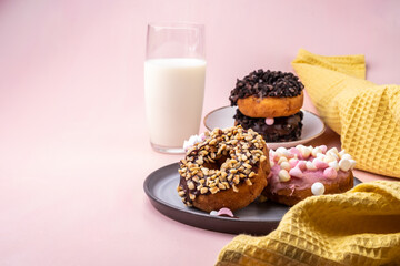 Donuts with different topping and icing on pink background. Sweet donuts