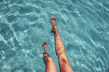 Woman legs playing in the pool