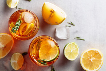 Traditional iced tea with lemon, lime and ice garnished with rosemary twigs.